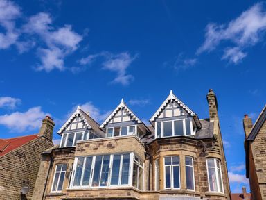 A stone building with three gabled windows under a blue sky at Ocean View in Alnmouth