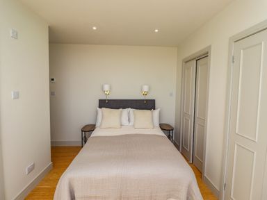 A bedroom with a double bed two bedside tables and wall lamps at Ocean View in Alnmouth
