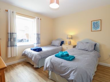 A bedroom with two single beds with blue towels on each bed at Beach House in Winterton-On-Sea