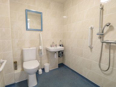 A bathroom with a toilet sink mirror and shower at Beach House in Winterton-On-Sea