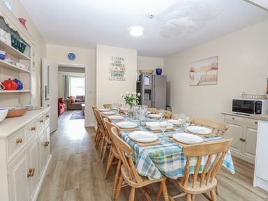 A dining room with a table set for dinner at Beach House Winterton-On-Sea
