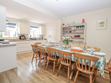 A dining room with a table set with dishes and glassware at Beach House Winterton-On-Sea