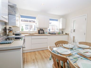 A kitchen with a dining table and chairs at Beach House Winterton-On-Sea