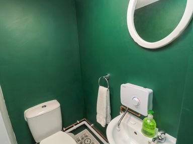 A small bathroom with a toilet sink towel and mirror at The Old Factory House in Berwick-Upon-Tweed