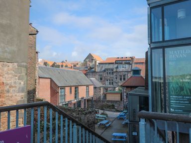 An outdoor courtyard with picnic tables and a mix of stone and brick buildings at The Old Factory House in Berwick-Upon-Tweed