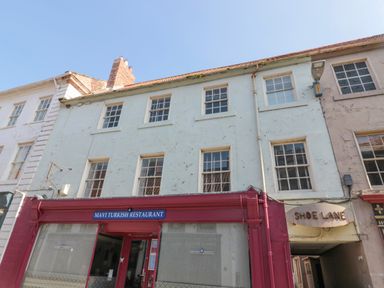 The exterior of Mavi Turkish Restaurant on a street with adjoining buildings and a sign for Shoe Lane at The Old Factory House in Berwick-Upon-Tweed