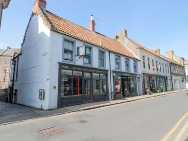 A street view of artisan food and drink shops and other businesses along a road at The Old Factory House in Berwick-Upon-Tweed