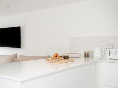 A kitchen counter with a kettle toaster jars and a plate of croissants with coffee at 100 Hillside Villas in Looe