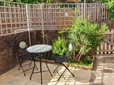 A garden with a table and two chairs at Old Ropemakers Cottage in Bridport