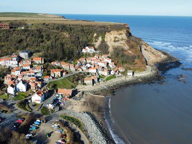 A coastal village with houses near cliffs and a beach at Lodge 18 - The Pines in Runswick Bay
