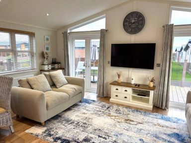A living room with a sofa and television at Lodge 18 - The Pines Runswick Bay