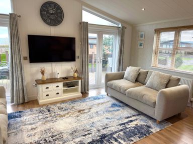 A living room with a television and sofa at Lodge 18 - The Pines Runswick Bay
