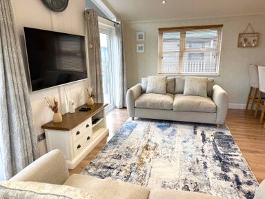 A living room with a sofa and TV at Lodge 18 - The Pines, Runswick Bay