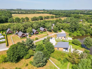 An outdoor view of cabins and greenery at Silver Birch in Dolton