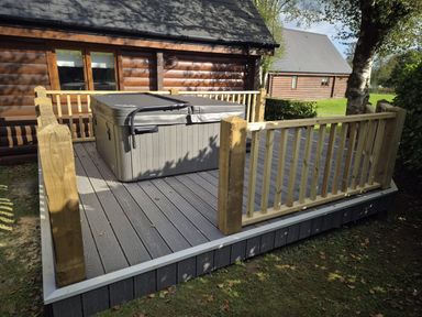 An outdoor area with a hot tub on a deck at Willow in Dolton