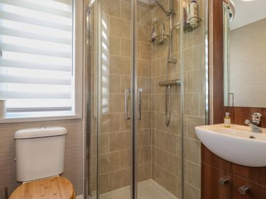 A bathroom with a shower enclosure toilet and sink at Capenwray in Carnforth