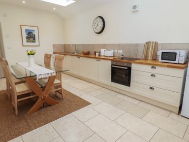A kitchen with a dining table and chairs at Cragg Lodge West Woodburn