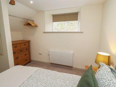 A bedroom with a bed and dresser at Cragg Lodge West Woodburn