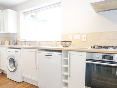 A kitchen with a washing machine dishwasher oven stovetop and countertop at The Brambles in Monmouth