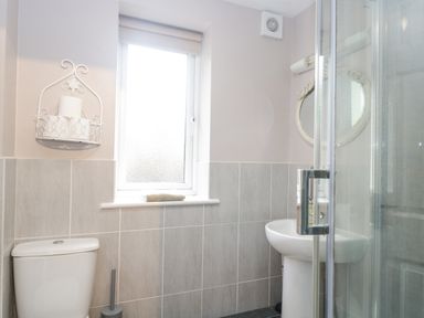 A bathroom with a toilet sink shower and a window at The Brambles in Monmouth