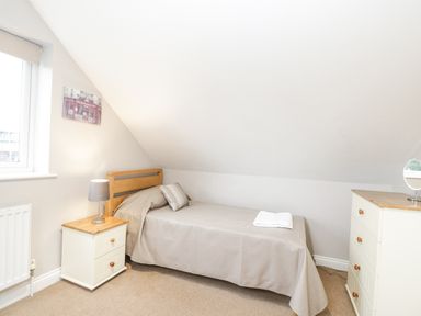 A bedroom with a single bed bedside table with a lamp and a chest of drawers at The Brambles in Monmouth