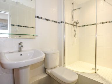 A bathroom with a sink toilet and a shower enclosure at Swyn Llyr in Rhosneigr