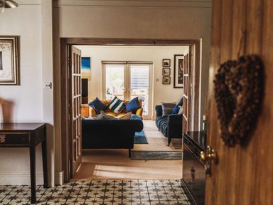 A view into a living room with a sofa and table at Glanllyn Bach, Llanfaelog
