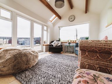 A conservatory with seating and a view at Glanllyn Bach in Llanfaelog