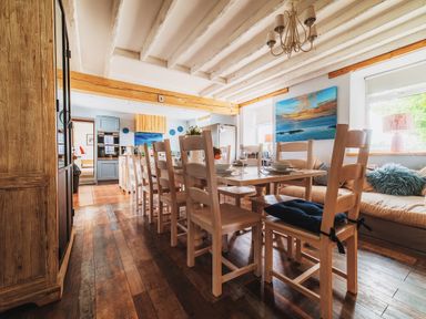 A dining room with a large table and chairs at Glanllyn Bach in Llanfaelog