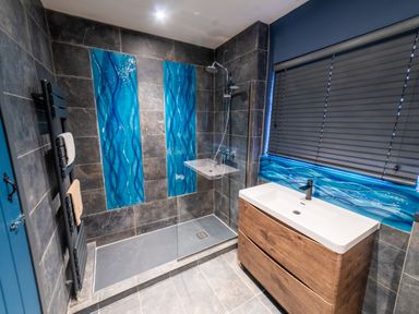 A bathroom with a shower and sink at Glanllyn Bach in Llanfaelog
