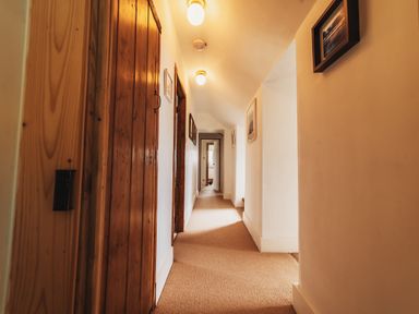 A hallway with doors and light fixtures at Glanllyn Bach Llanfaelog