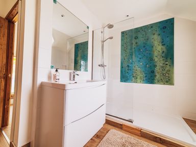 A bathroom with a shower and sink at Glanllyn Bach in Llanfaelog