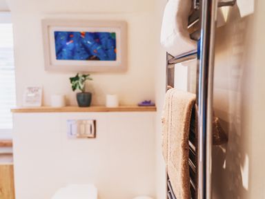 A bathroom with a towel rack and a toilet at Glanllyn Bach Llanfaelog