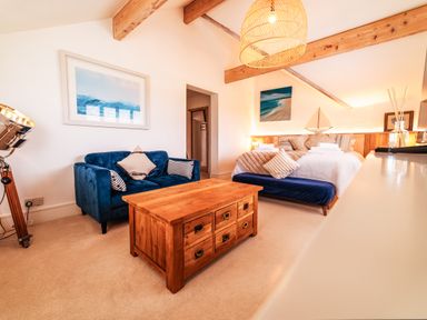 A bedroom with a blue sofa and wooden coffee table at Glanllyn Bach in Llanfaelog