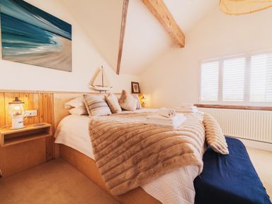 A bedroom with a bed and window at Glanllyn Bach in Llanfaelog