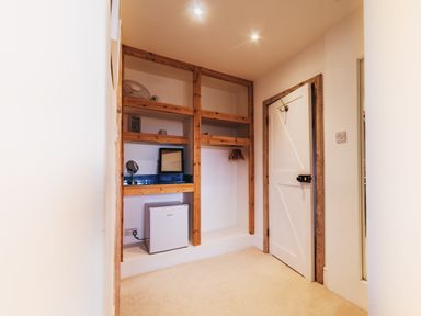 A storage room with shelves and appliances at Glanllyn Bach in Llanfaelog
