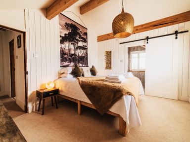 A bedroom with a bed and bedside table at Glanllyn Bach in Llanfaelog