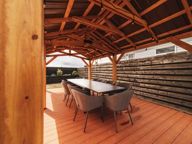 A wooden pavilion with a dining table and chairs at Glanllyn Bach in Llanfaelog