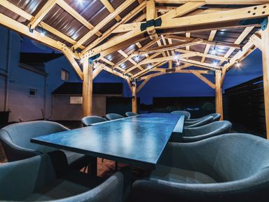 An outdoor dining area with a wooden structure and table at Glanllyn Bach in Llanfaelog