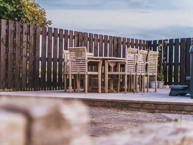 An outdoor dining area with a table and chairs at Glanllyn Bach in Llanfaelog