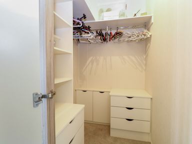 A walk-in closet with shelves drawers and hangers at 21 Norman Drive Lodge in Burgh Castle