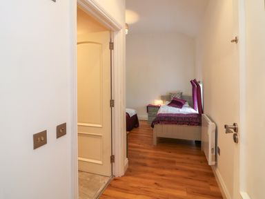 A bedroom with two single beds a bedside table with a lamp and a radiator on the wall at The Farm Cottage in Athy County Kildare