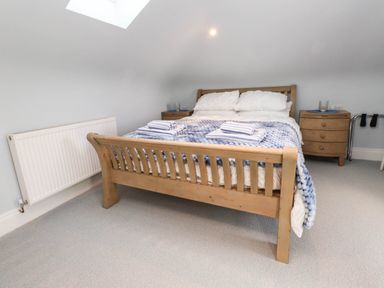 A bedroom with a wooden bed and bedside tables at Bryn Tirion in Morfa Nefyn