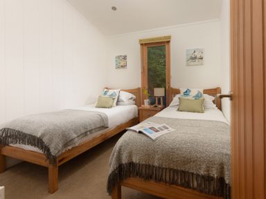 A bedroom with two single beds and a bedside table with a lamp at 10 Stonerush Valley Lanreath near Looe