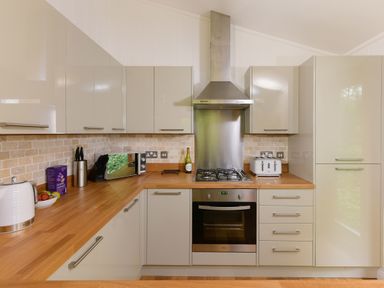 A kitchen with wooden countertops a gas stove an oven a microwave and cabinets at 10 Stonerush Valley Lanreath near Looe