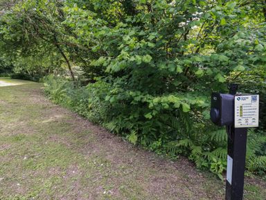 An outdoor area with grass and trees and an electric vehicle charging station at 10 Stonerush Valley Lanreath near Looe