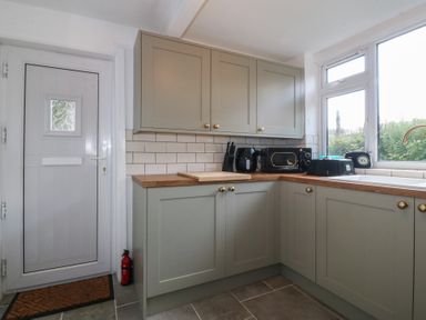 A kitchen with cabinets and appliances at Tan Y Merddyn in Ceunant near Llanrug