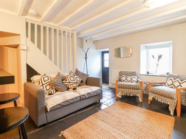 A living room with a sofa and two armchairs with patterned covers and cushions at Ty Dyffryn in Llan Ffestiniog