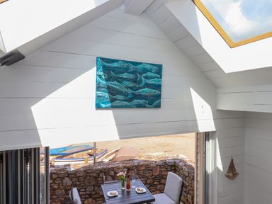 A small outdoor dining area with a table set for two on a stone patio at Beach Hut 5 in Shaldon