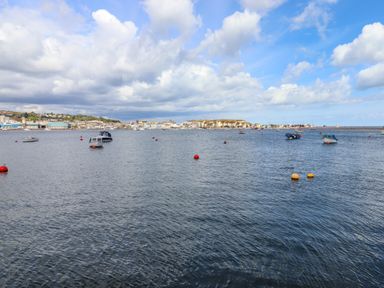 A coastal town with boats anchored in the water and buildings along the shoreline at Beach Hut 5 in Shaldon